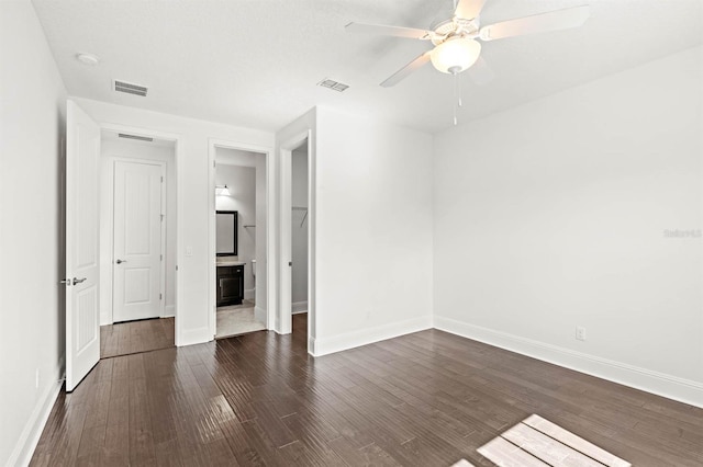 unfurnished bedroom with connected bathroom, ceiling fan, and dark wood-type flooring