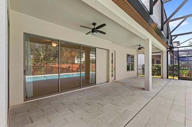 view of patio with glass enclosure and ceiling fan