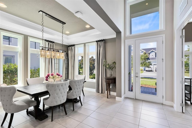 dining room featuring ornamental molding, a raised ceiling, and light tile patterned floors