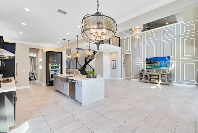 kitchen with stainless steel appliances, light tile patterned floors, an inviting chandelier, and decorative light fixtures