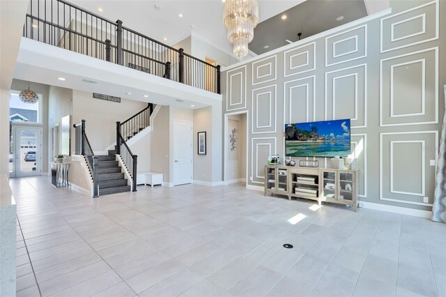 living room featuring light tile patterned floors, a towering ceiling, and a notable chandelier