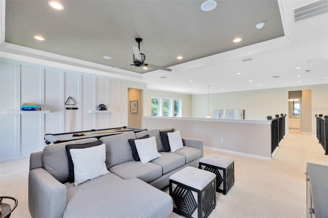 cinema with a raised ceiling, crown molding, light colored carpet, and ceiling fan