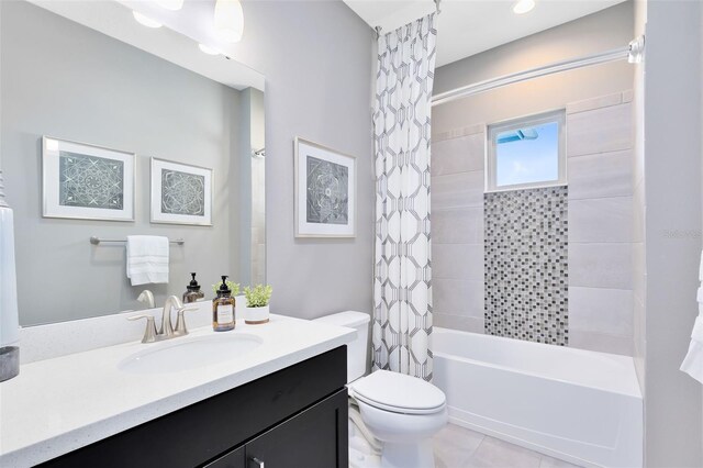 full bathroom with shower / tub combo with curtain, vanity, tile patterned flooring, and toilet