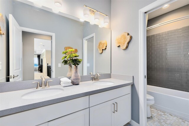 full bathroom featuring vanity, tile patterned flooring, tiled shower / bath combo, and toilet