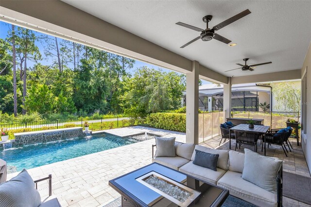 view of swimming pool featuring ceiling fan, a patio area, a jacuzzi, an outdoor living space with a fire pit, and pool water feature