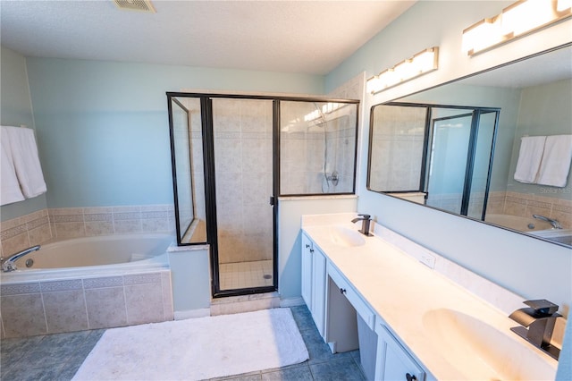 bathroom featuring tile patterned flooring, vanity, a textured ceiling, and plus walk in shower