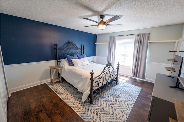 bedroom with a textured ceiling, ceiling fan, and dark hardwood / wood-style floors