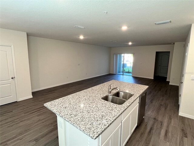 kitchen featuring white cabinetry, sink, an island with sink, and dark wood-type flooring