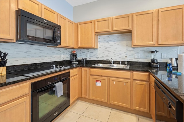 kitchen featuring tasteful backsplash, dark stone counters, sink, black appliances, and light tile patterned floors