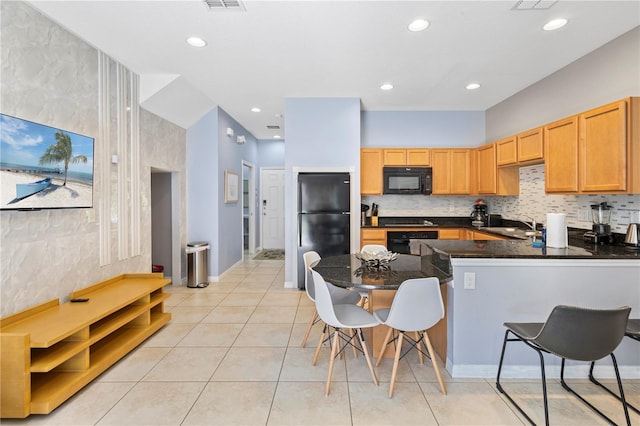 kitchen with sink, backsplash, kitchen peninsula, light tile patterned floors, and black appliances