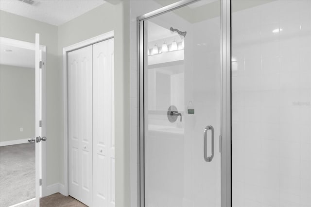 bathroom featuring a shower with door and a textured ceiling