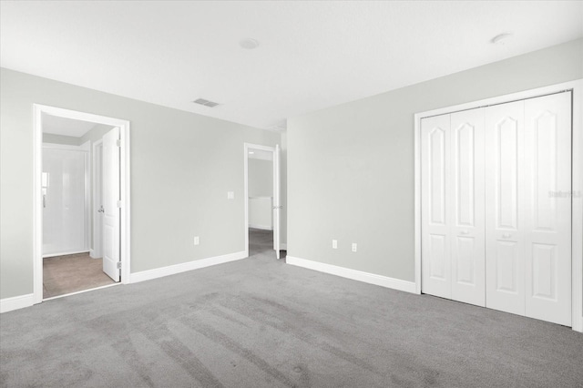 unfurnished bedroom with carpet, ensuite bath, and a closet