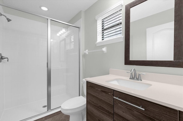 bathroom featuring tile patterned flooring, vanity, toilet, and walk in shower