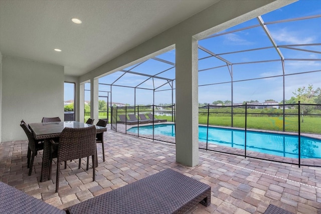 view of swimming pool with glass enclosure and a patio