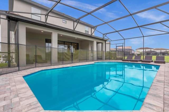 view of pool featuring glass enclosure and a patio area