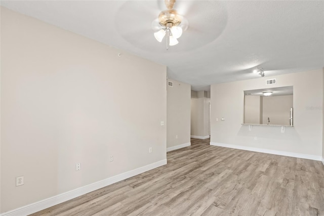 spare room featuring ceiling fan, a textured ceiling, and light wood-type flooring