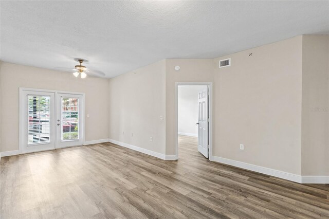 spare room featuring a textured ceiling, wood-type flooring, and ceiling fan