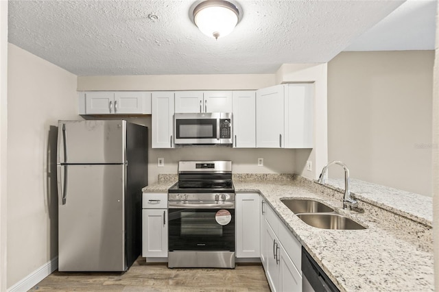 kitchen featuring appliances with stainless steel finishes, sink, and white cabinets