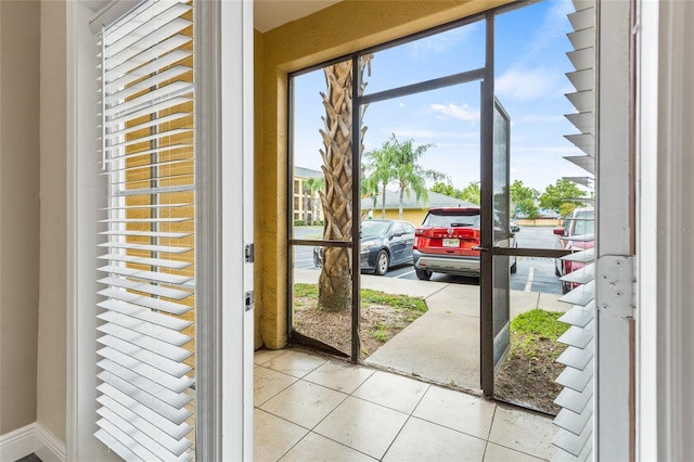 doorway to outside with light tile patterned floors