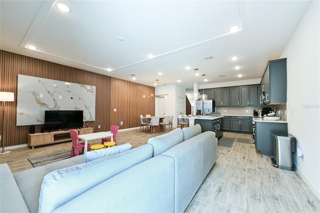 living room featuring wooden walls and light hardwood / wood-style flooring