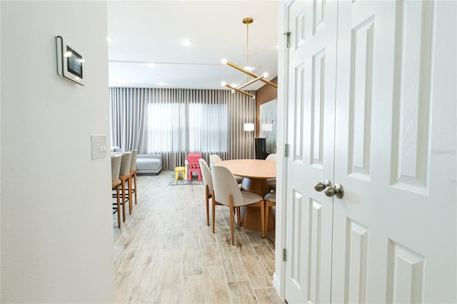 dining space featuring light hardwood / wood-style floors and a notable chandelier