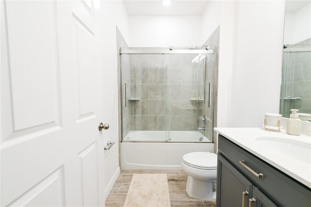 full bathroom with vanity, toilet, and combined bath / shower with glass door