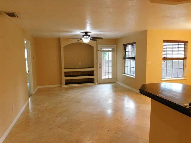 unfurnished living room with ceiling fan