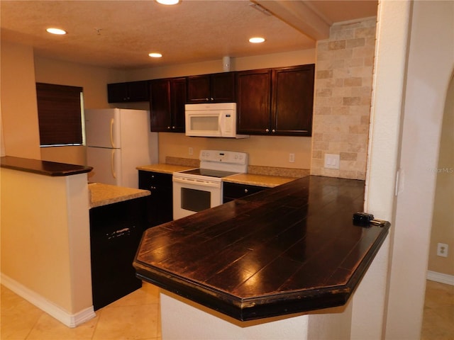 kitchen featuring light tile patterned floors, white appliances, and kitchen peninsula