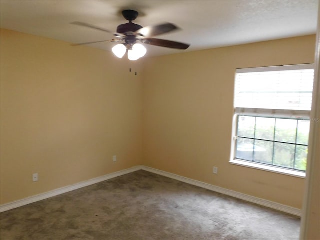 carpeted spare room featuring ceiling fan