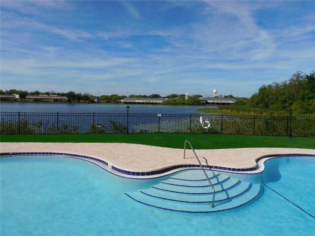 view of swimming pool with a yard and a water view