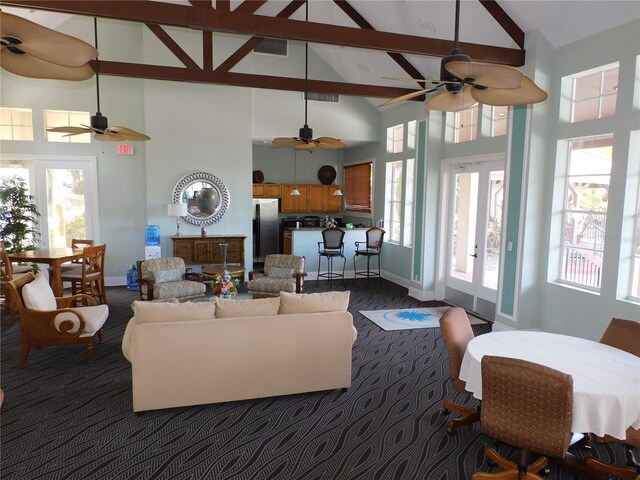 living room featuring french doors, high vaulted ceiling, plenty of natural light, and beam ceiling