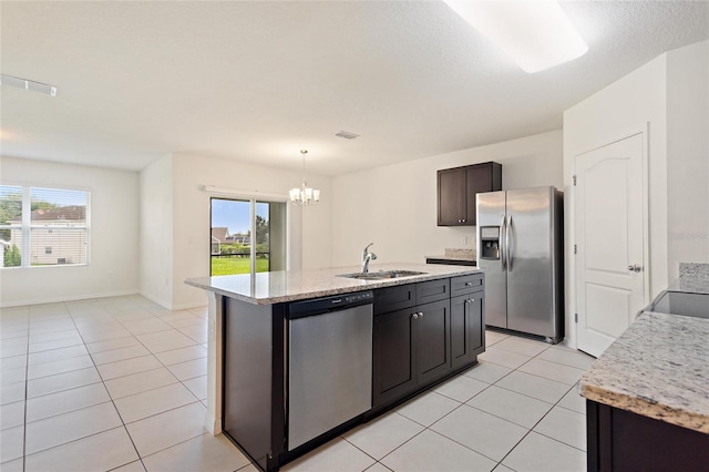 kitchen with sink, decorative light fixtures, stainless steel appliances, and an island with sink