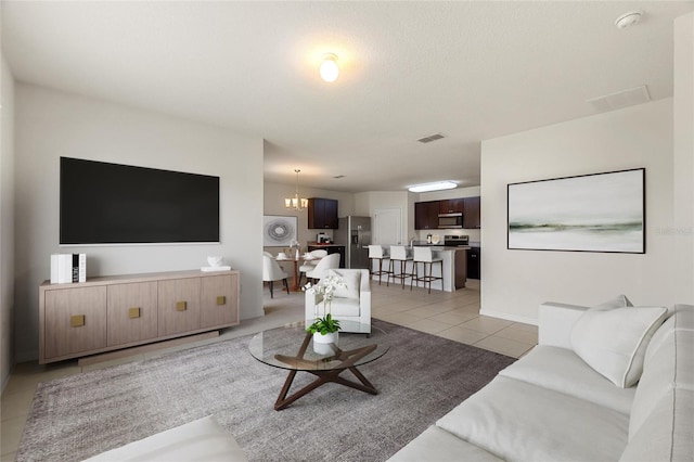 living room with a notable chandelier and light tile patterned flooring