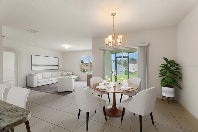 tiled dining room featuring an inviting chandelier