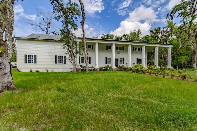 rear view of property featuring a lawn