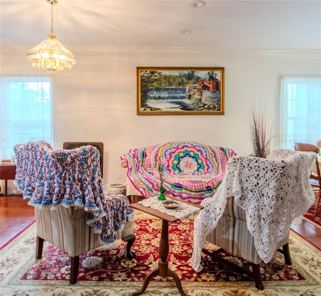 interior space with hardwood / wood-style floors, an inviting chandelier, and ornamental molding