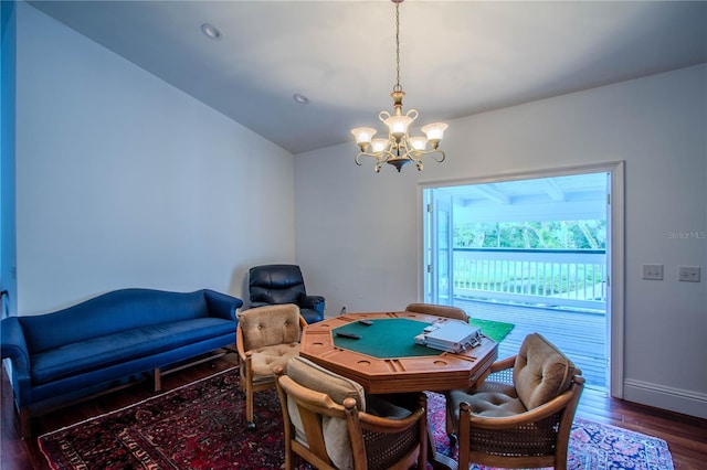 game room featuring dark hardwood / wood-style flooring, vaulted ceiling, and an inviting chandelier