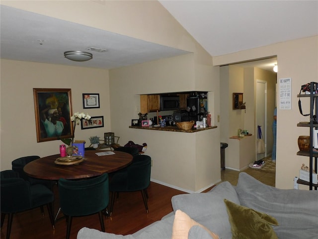 dining space with light hardwood / wood-style flooring and lofted ceiling