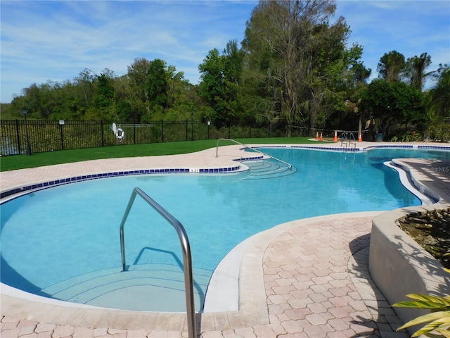 view of pool featuring a lawn