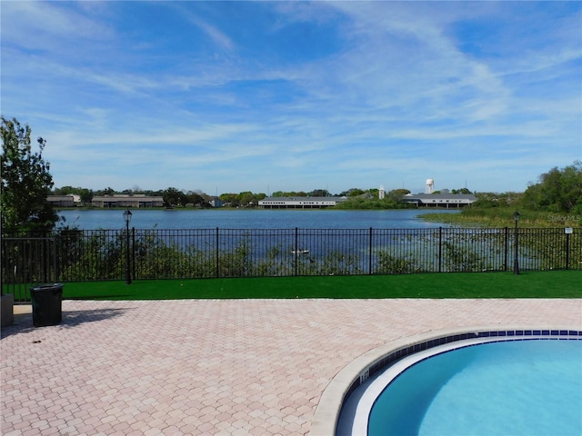 view of pool featuring a yard and a water view