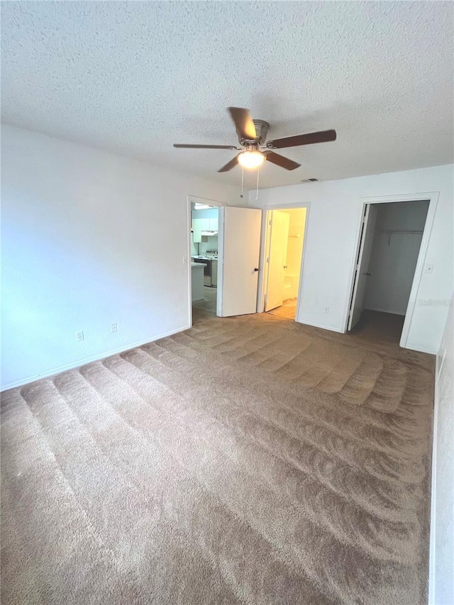 carpeted spare room with ceiling fan and a textured ceiling