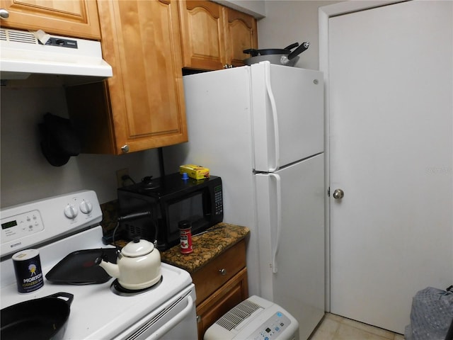 kitchen with dark stone countertops, white range oven, and light tile patterned floors