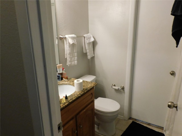 bathroom with vanity, toilet, and tile patterned floors