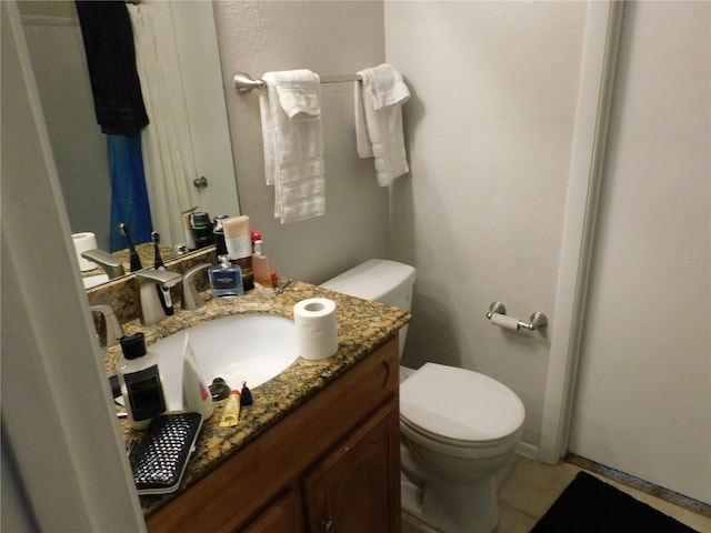 bathroom featuring toilet, tile patterned floors, and vanity