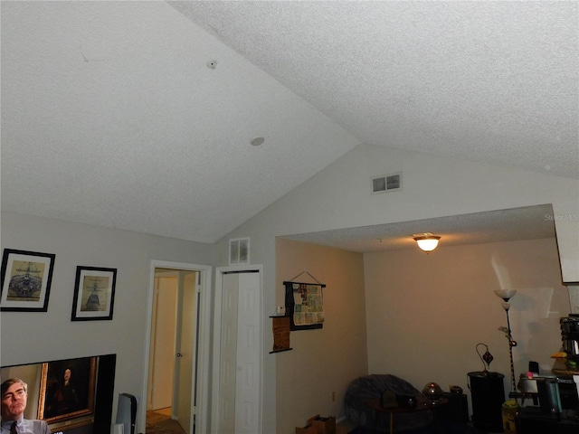 living room featuring vaulted ceiling and a textured ceiling