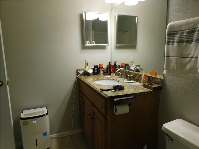 bathroom featuring toilet, tile patterned floors, and vanity