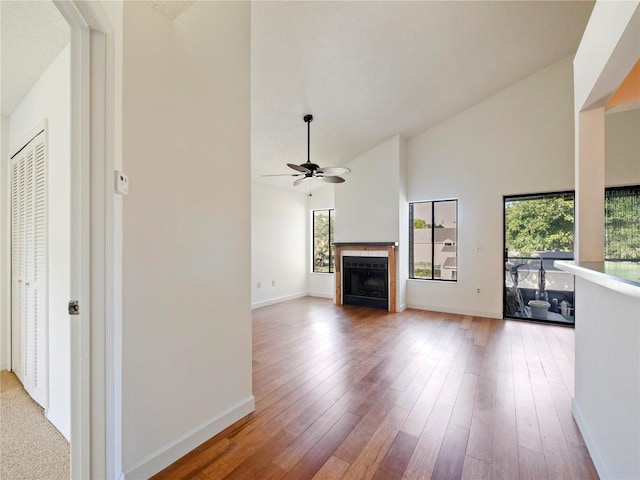 unfurnished living room with high vaulted ceiling, ceiling fan, and hardwood / wood-style flooring