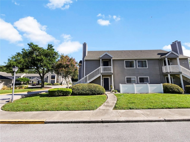 view of front of property with a front lawn and a balcony