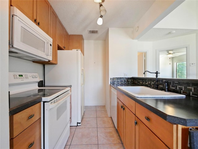 kitchen featuring ceiling fan, light tile patterned floors, sink, a textured ceiling, and white appliances