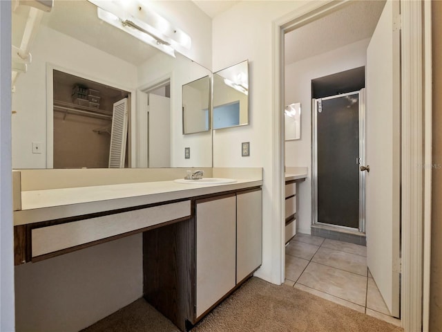 bathroom with tile patterned flooring, a shower with shower door, and vanity